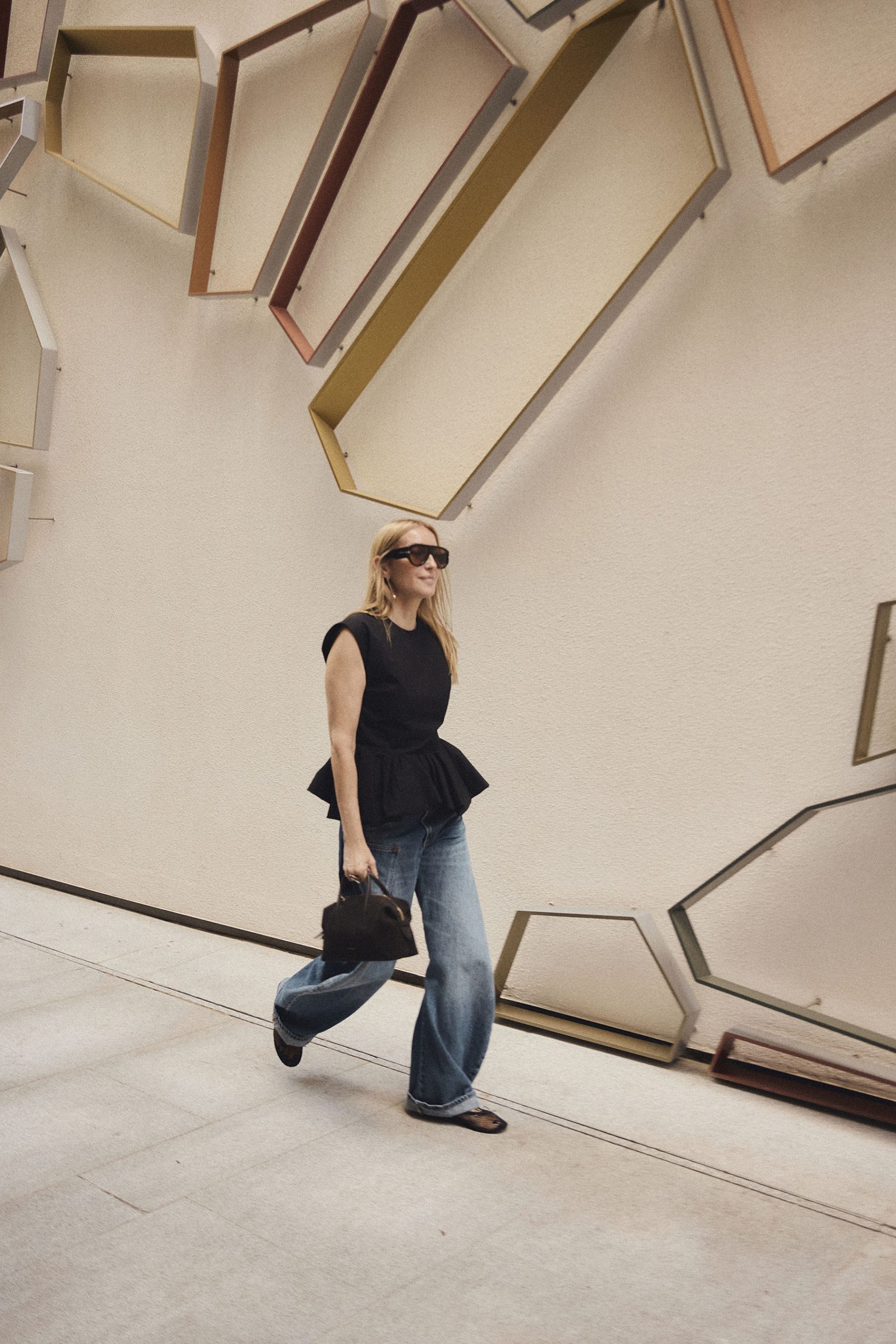 Bolso Stockholm de DeMellier London en ante chocolate en movimiento, integrado en un look contemporáneo